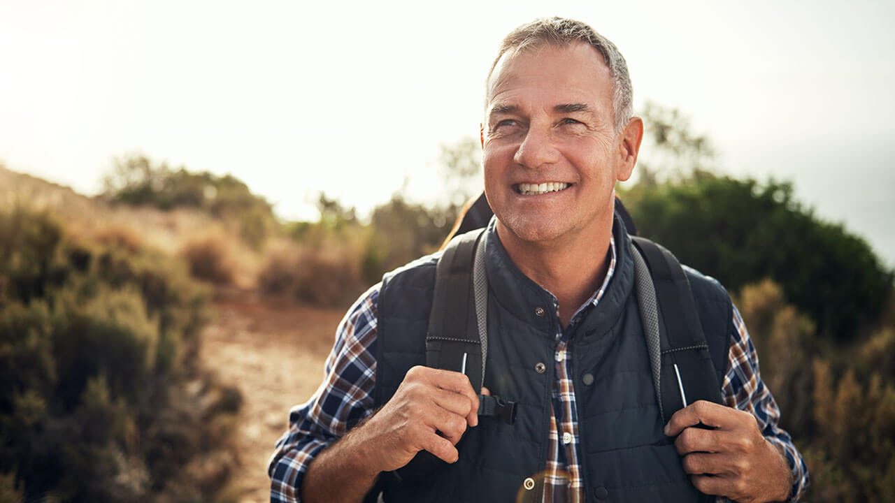 Middle age male hiking with a backpack on shoulders