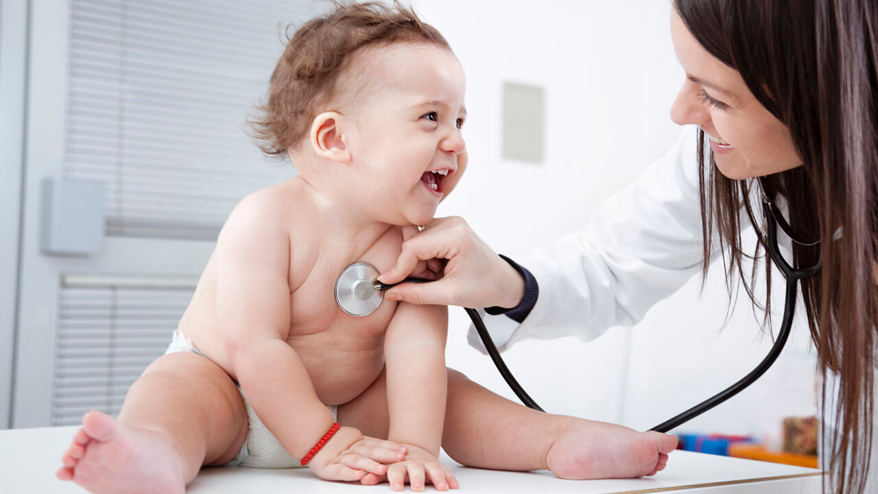 baby smiling with stethoscope on chest