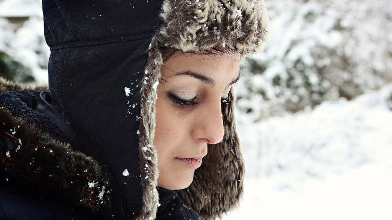 Woman appears to be sad or upset standing outside in the snow