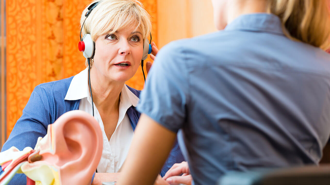 Senior woman wearing a hearing headphones during a hearing exam