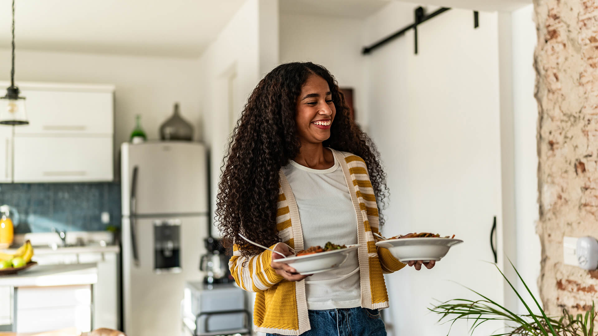 Young woman serving lunch at home