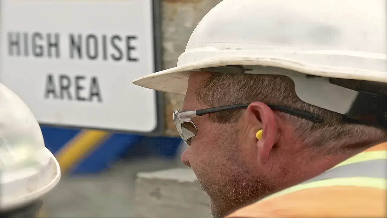 A construction worker with earplugs.