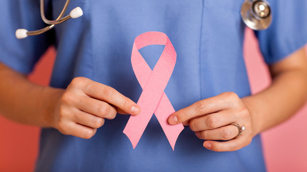Female doctor holding a pink breast cancer ribbon
