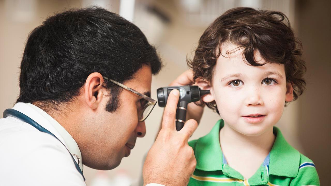 Doctor looking at child's ear with an otoscope