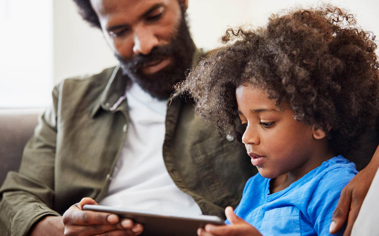 Father and daughter looking at an electronic tablet
