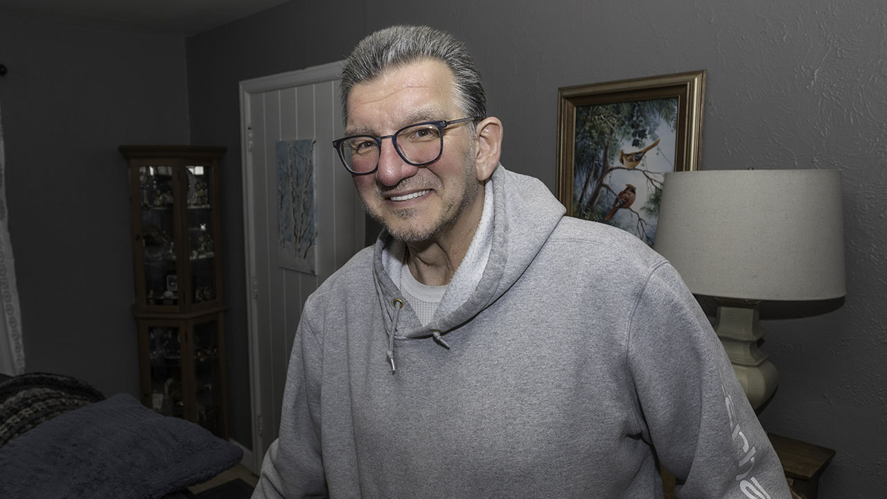 Chuck standing in a living room smiling at the camera