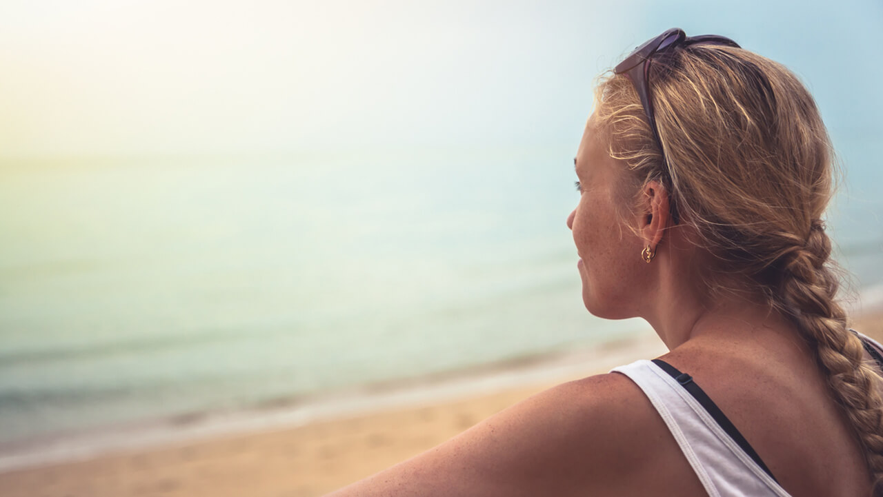 woman looking out towards body of water