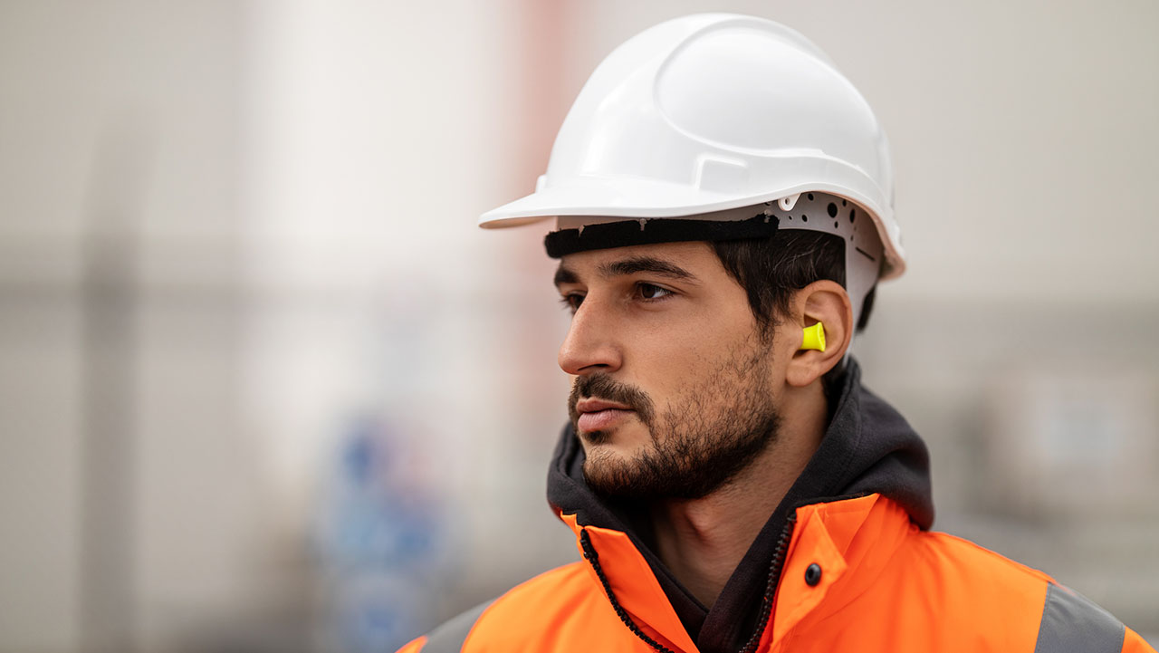 A construction worker with earplugs.