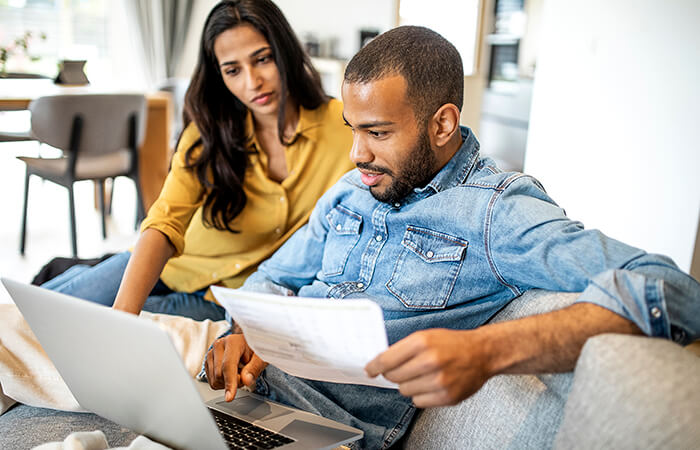 middle aged man and woman reviewing notes on couch