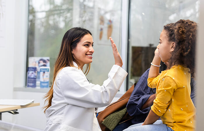 young doctor high fives child patient