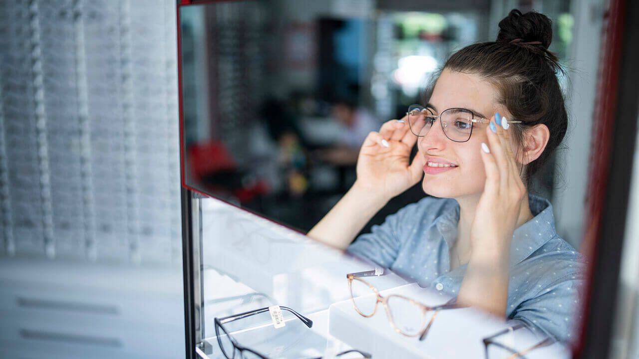 Young woman choosing new glasses