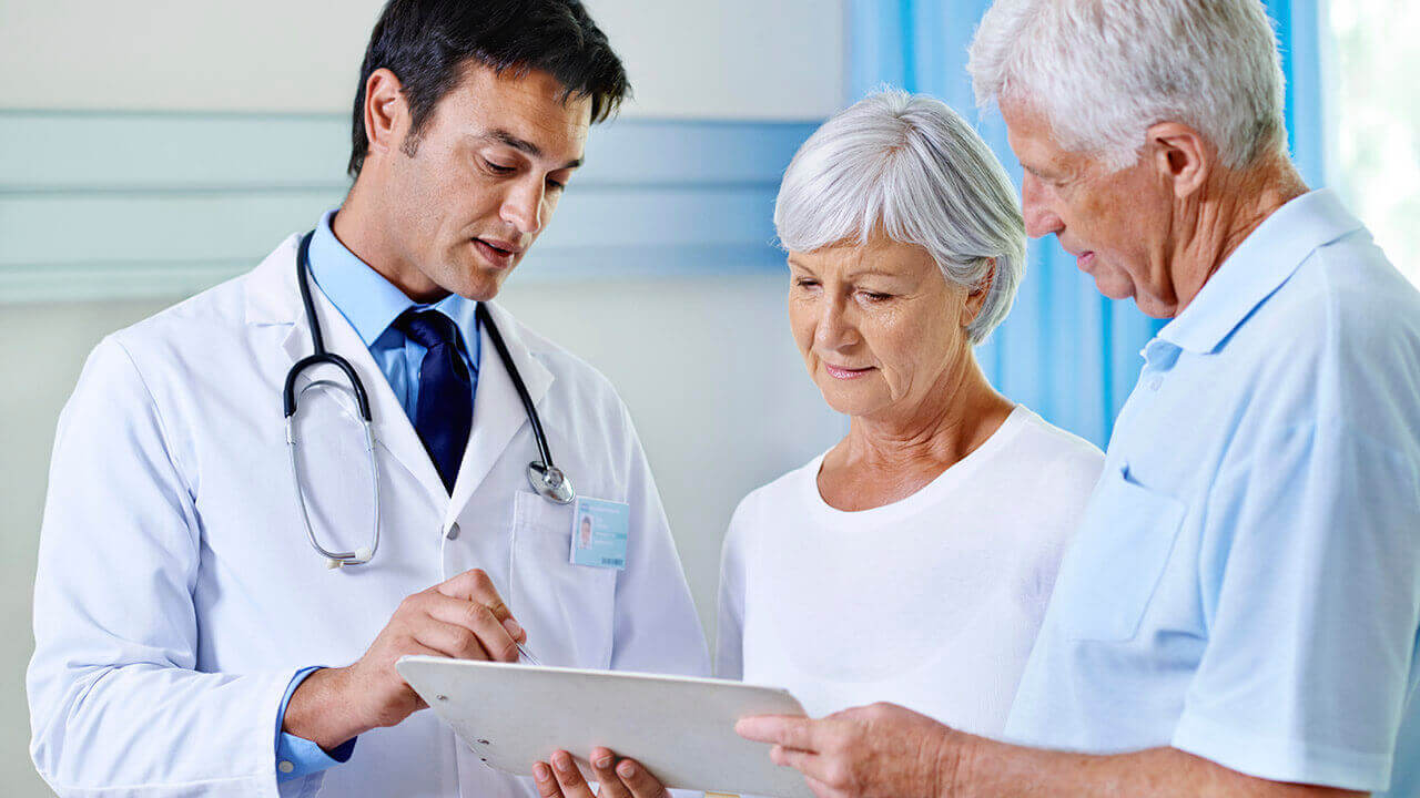 Male doctor showing elderly couple a chart