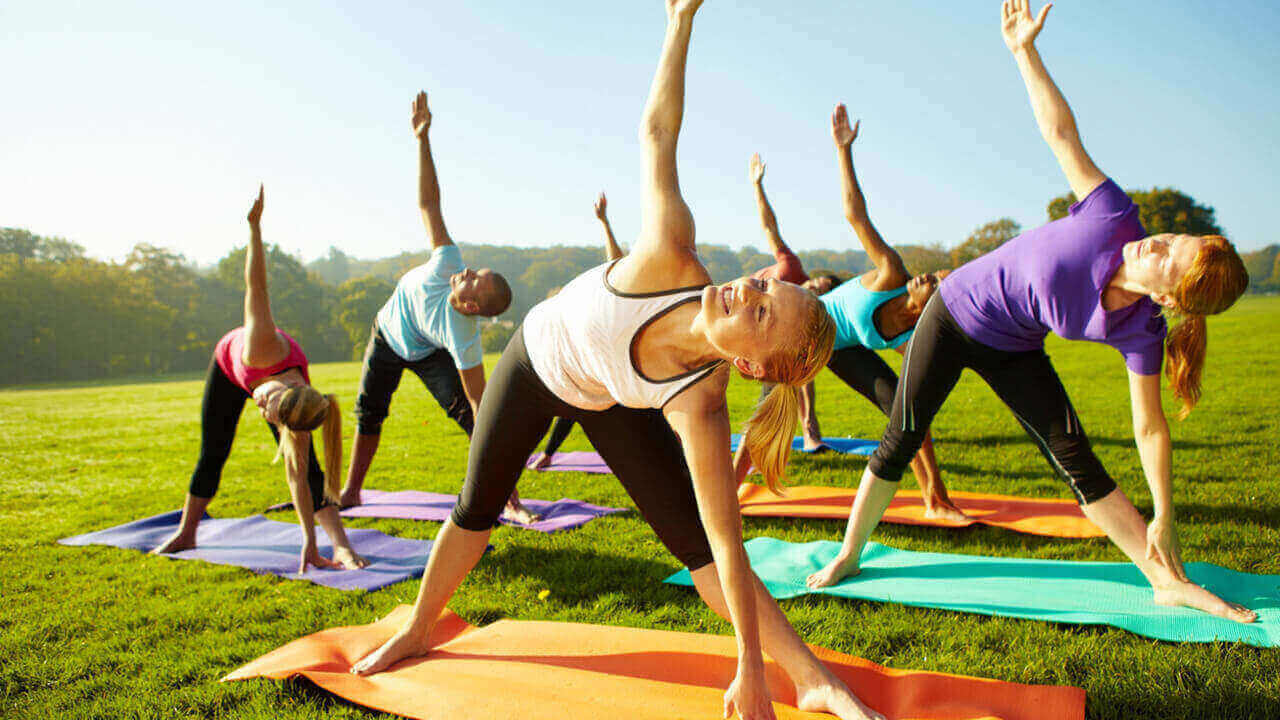 multiple people doing yoga poses outside