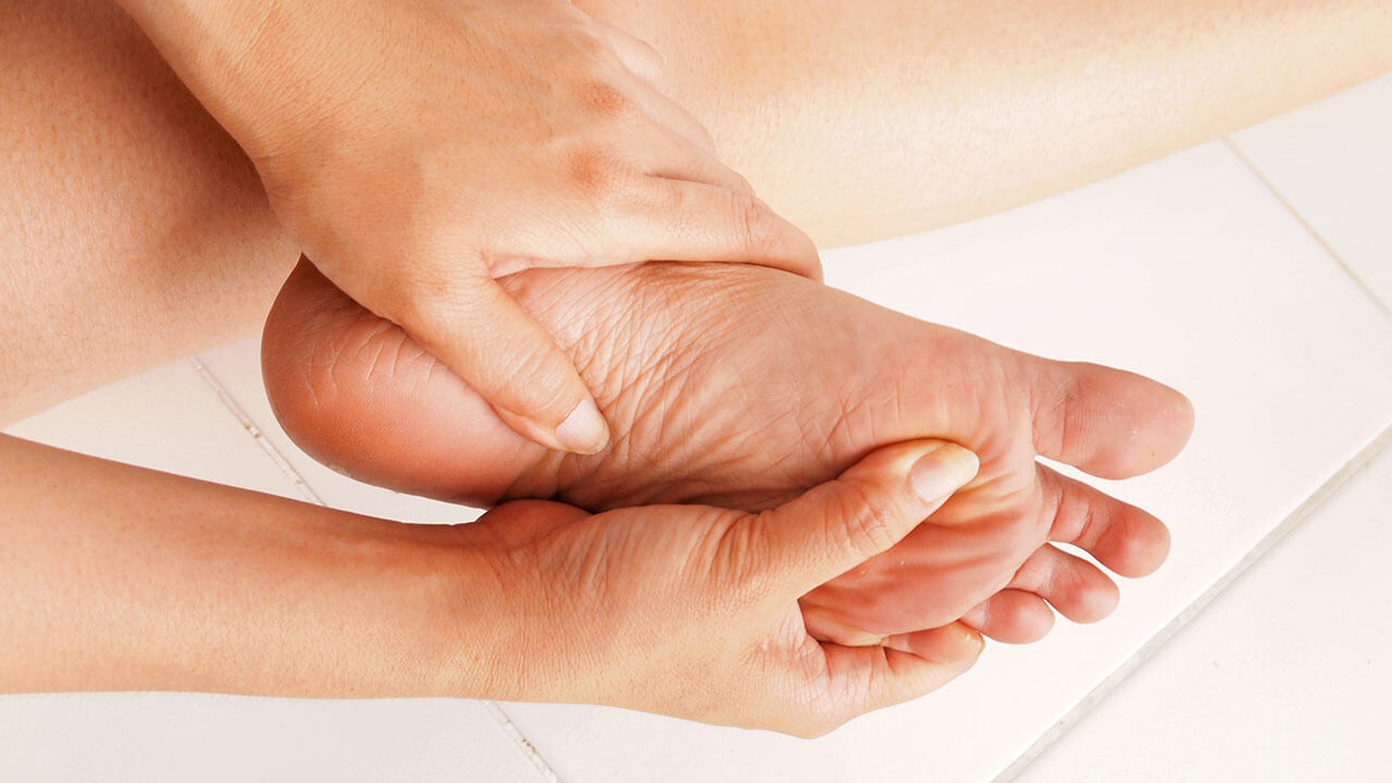 Woman holding her left foot with both hands