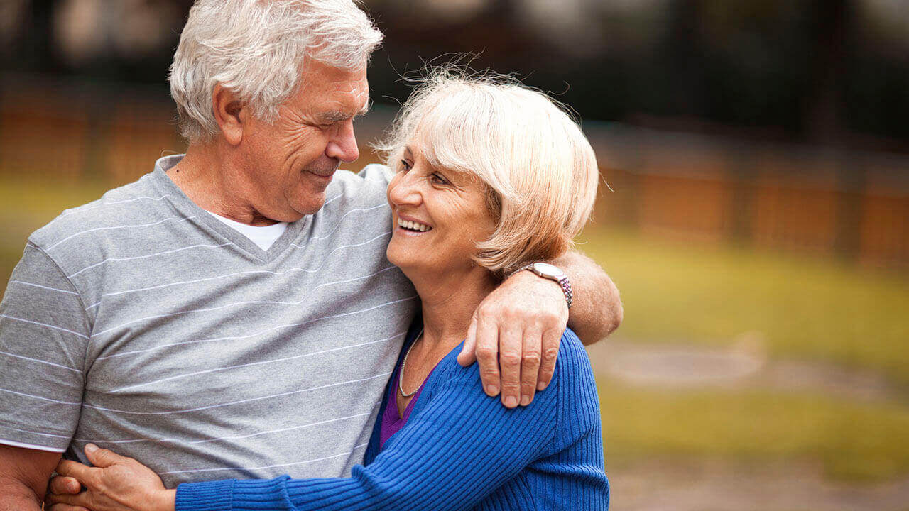 senior male with his arm around his wife