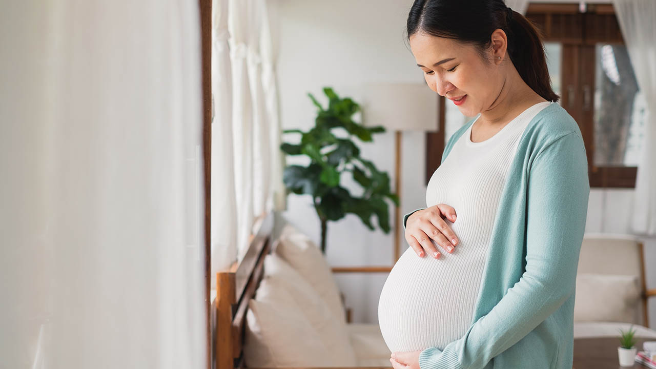 A pregnant woman holding her belly.