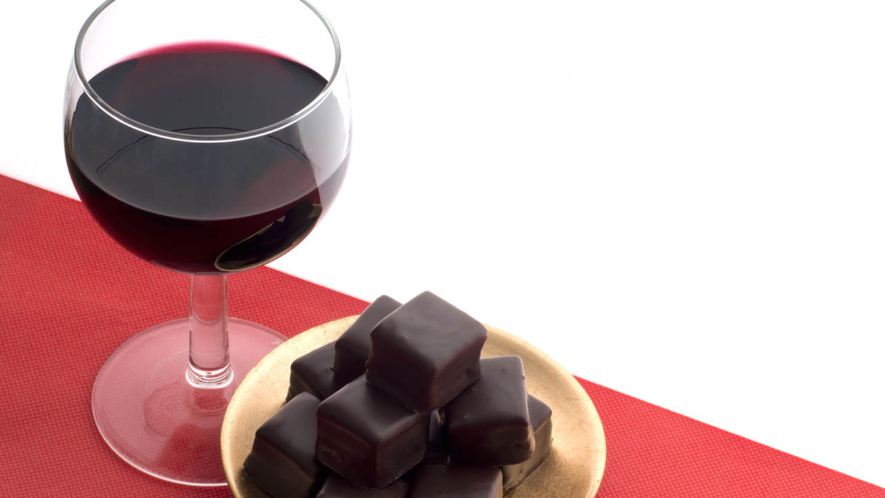 glass of red wine and chocolate squares