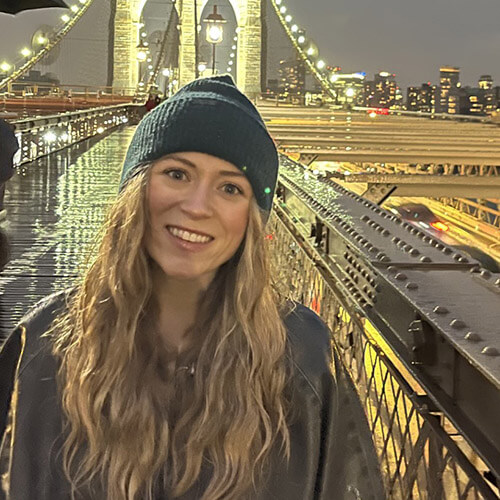 Patient morgan smiling at the camera while standing on the Brooklyn Bridge.