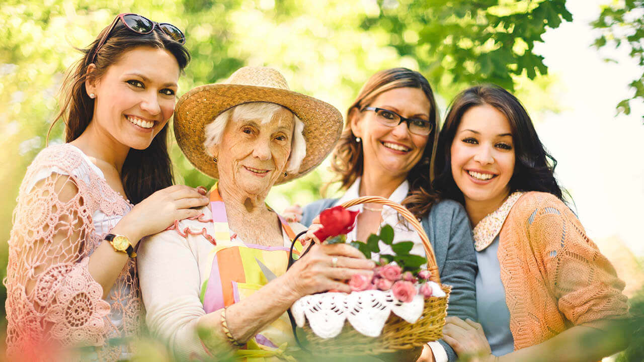 Group of women of different generations posing for a photo outside