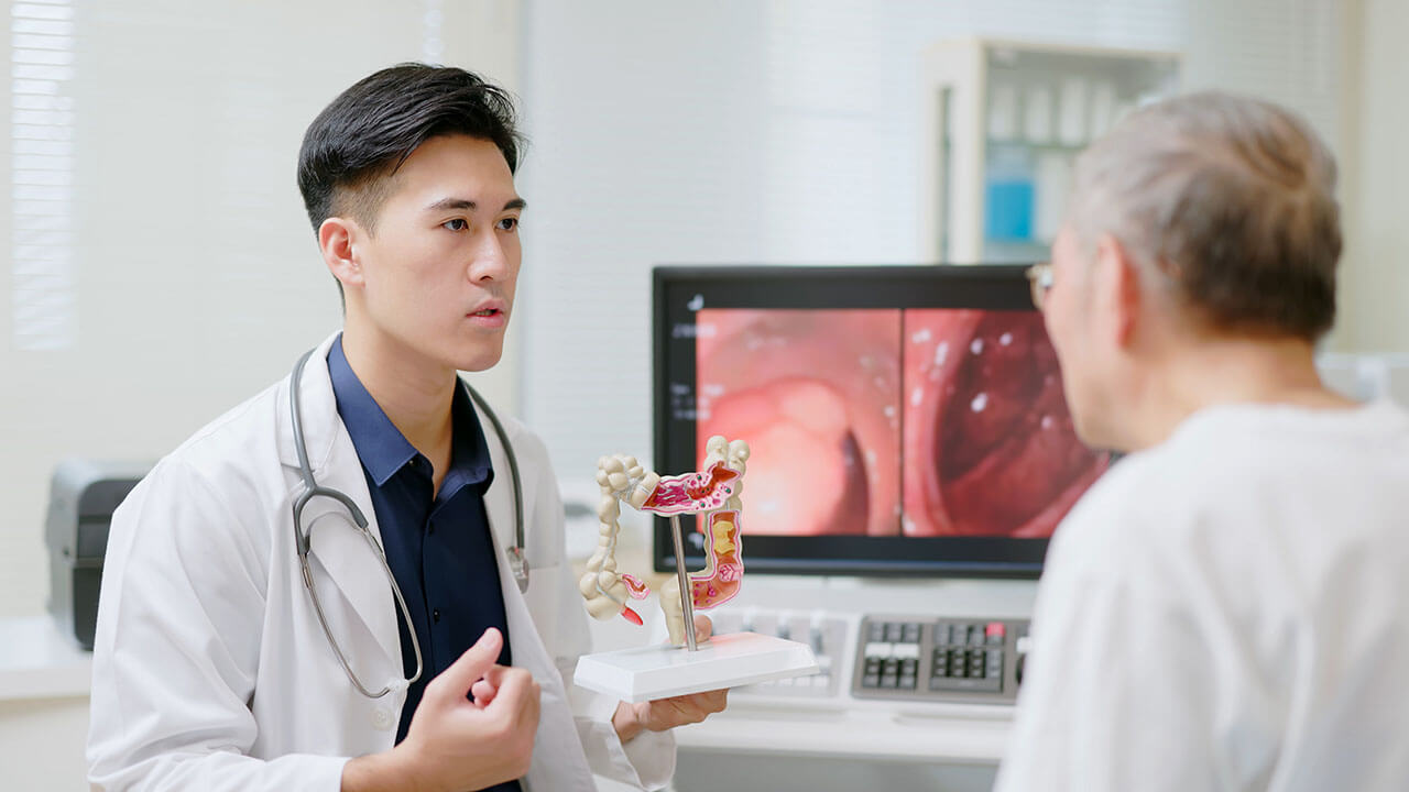 Doctor holding colon model and talking to patient