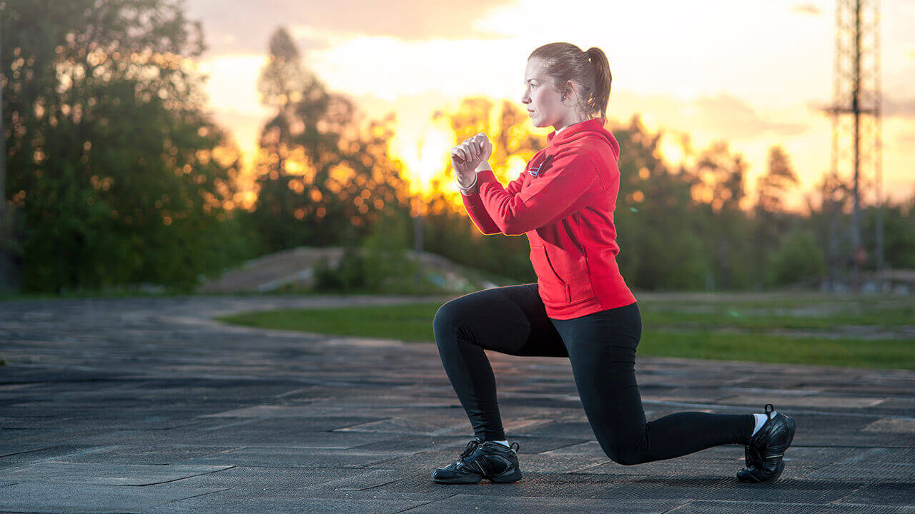woman doing lunges outside