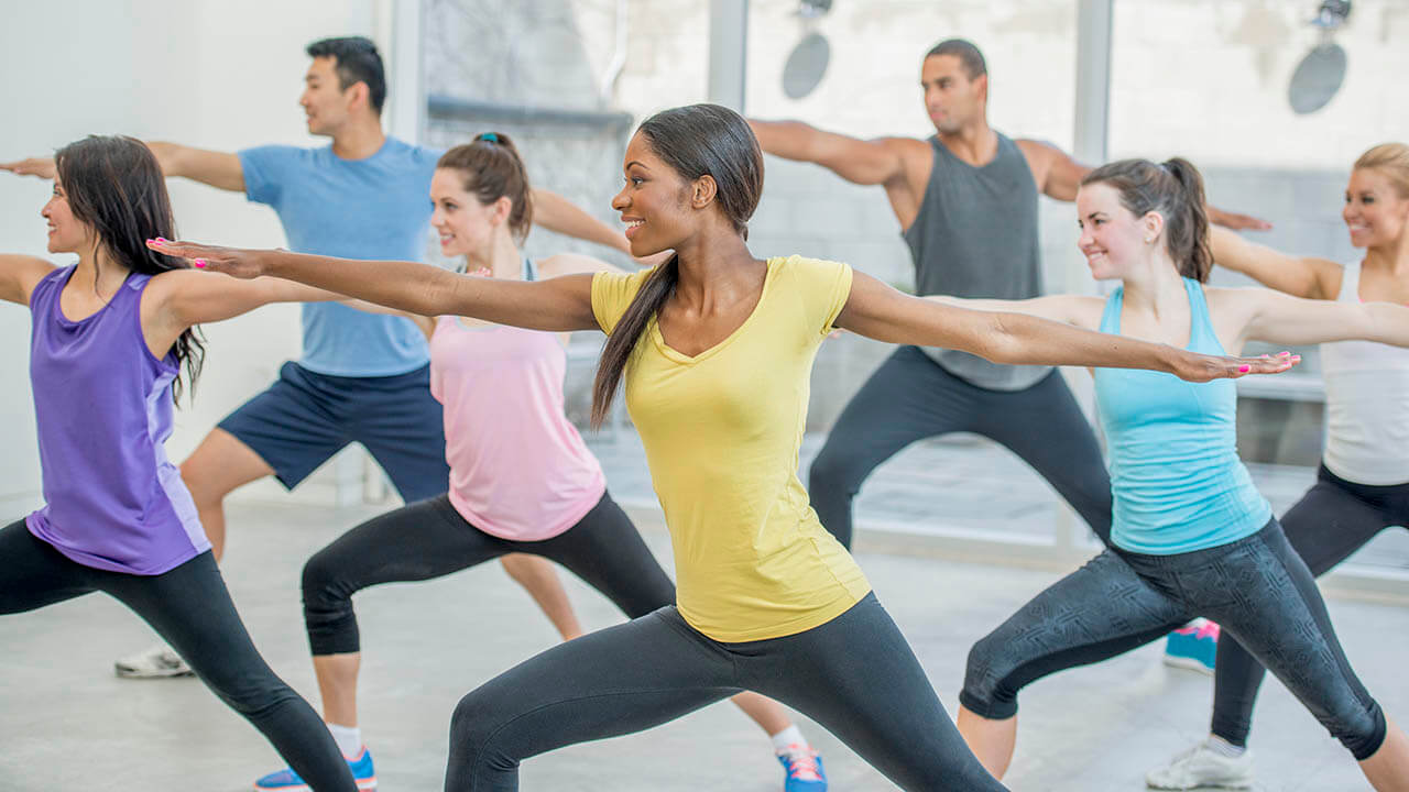 Group of people performing a yoga pose in a studio