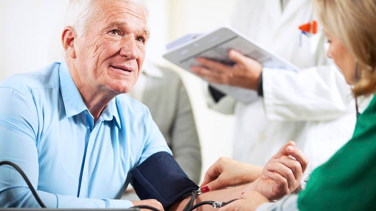 Senior man getting blood pressure measured by nurse