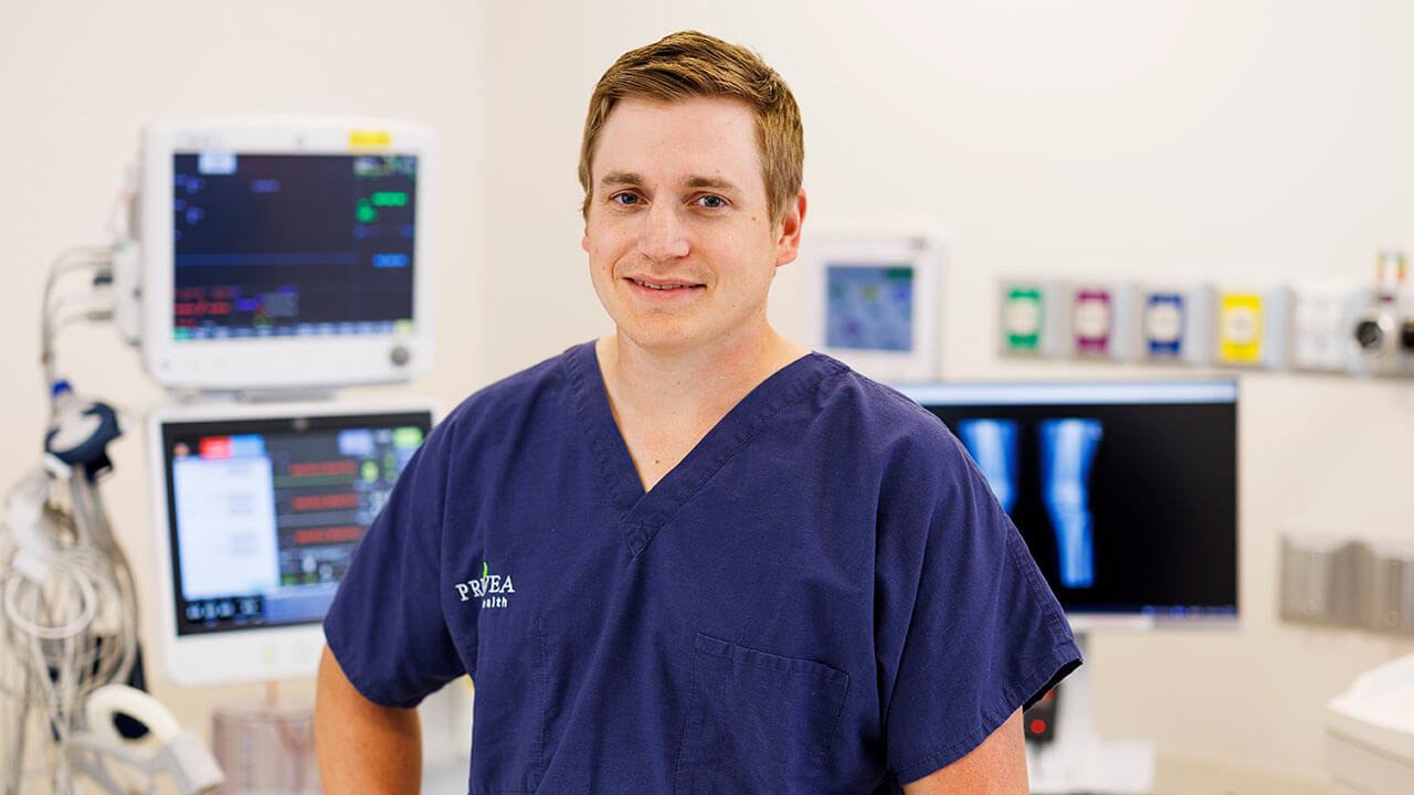 Dr. Riggle smiling at the camera in a clinic room